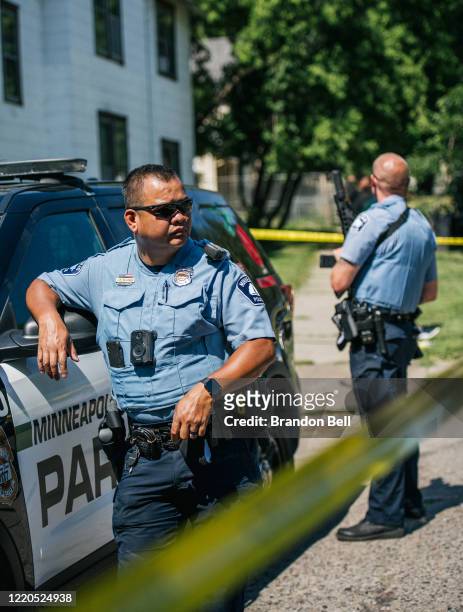 Minneapolis Police officers stand behind caution tape at a crime scene on June 16, 2020 in Minneapolis, Minnesota. The Minneapolis Police Department...