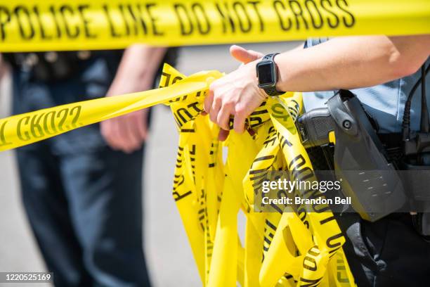 Minneapolis Police officer rolls up caution tape at a crime scene on June 16, 2020 in Minneapolis, Minnesota. The Minneapolis Police Department has...