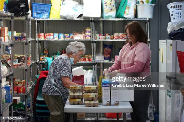 Volunteers Felicity Baker and Jess Proctor prepare essential food packs at St Paul's Anglican Church Parish Pantry for those in need on April 23,...