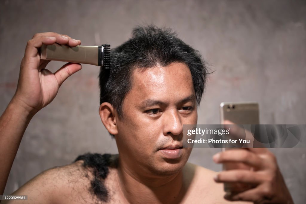 Asian men are learning to cut their own hair due to The corona virus or Covid-19 is spreading. Most people have to stay home to reduce the outbreak.