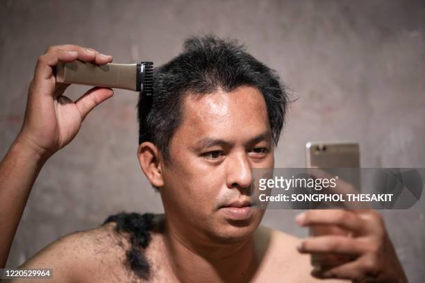 asian men are learning to cut their own hair due to the corona virus or covid-19 is spreading. most people have to stay home to reduce the outbreak. - man with gray hair stock pictures, royalty-free photos & images