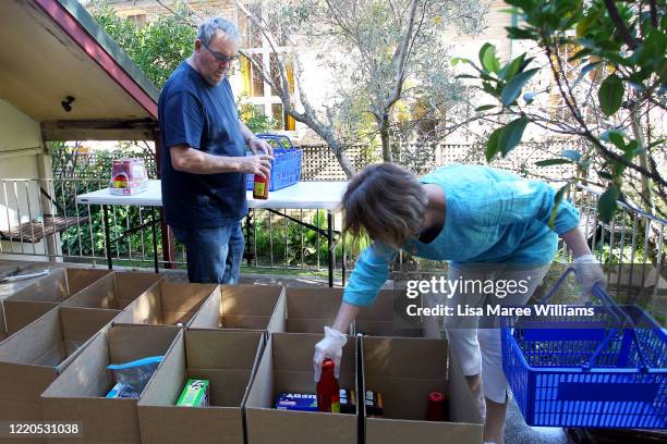 Dr Bob Woods and Dr Jane Carrick, volunteers at St Paul's Anglican Church Parish Pantry prepare essential food packs on April 23, 2020 in Sydney,...