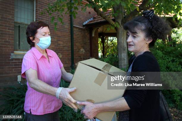 Volunteer Kerin Brown assists a local woman with an essential food pack at St Paul's Anglican Church Parish Pantry for those in need on April 23,...