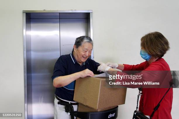 Dr Jane Carrick a volunteer at St Paul's Anglican Church Parish Pantry delivers an essential food pack to an elderly man on April 21, 2020 in Sydney,...
