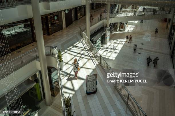 People walk through the Mall of America on June 16, 2020 in Bloomington, Minnesota, after some of the shops at the mall reopened on June 10. - The...