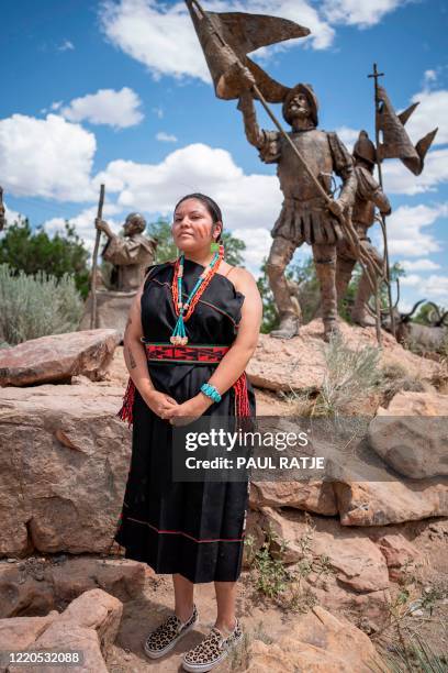 AmericanHorse, Hopi and Oglala Lakota heritage, poses for a portrait in front of a sculpture of Spanish settlers where the main character...