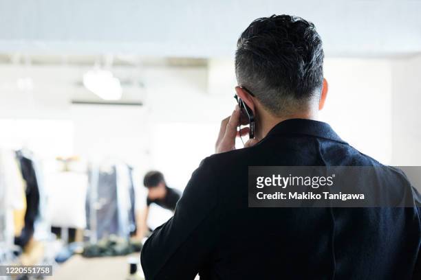 japanese businessman talking on cell phone - ear stockfoto's en -beelden
