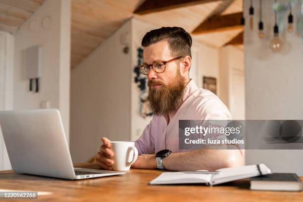 man doing an online job search at home - unemployment benefits stock pictures, royalty-free photos & images