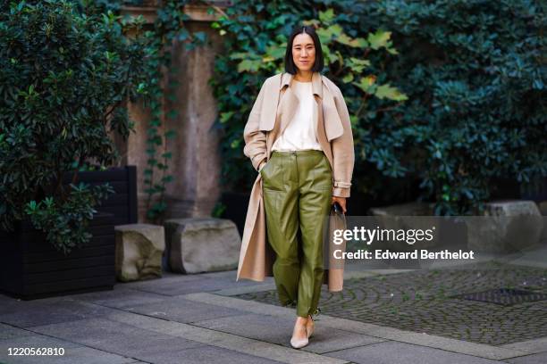 Eva Chen wears a beige long coat, a white t-shirt, green leather pants, pointy shoes, outside Koche x Pucci, during Milan Fashion Week Fall/Winter...