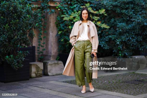 Eva Chen wears a beige long coat, a white t-shirt, green leather pants, pointy shoes, outside Koche x Pucci, during Milan Fashion Week Fall/Winter...