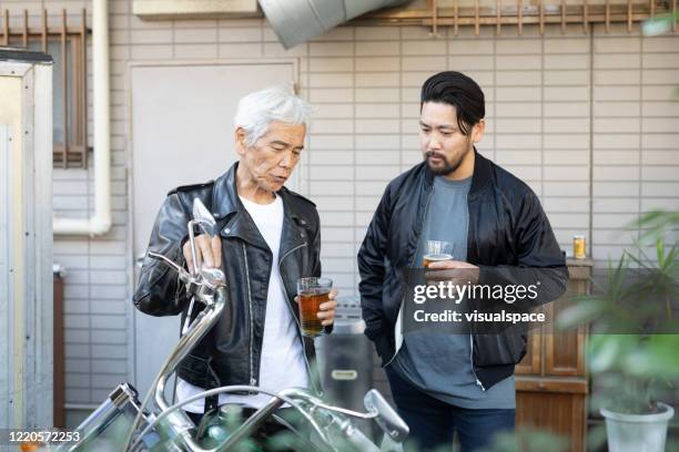 father and son having a beer together - old garage at home stock pictures, royalty-free photos & images