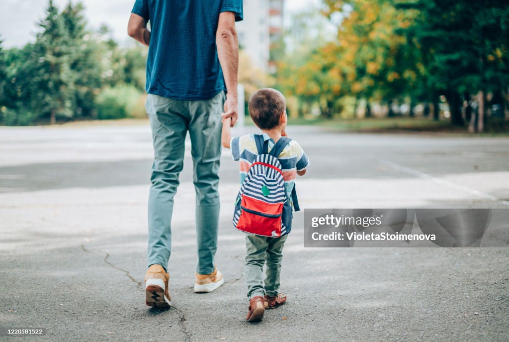 Vater und Sohn gehen in den Kindergarten.