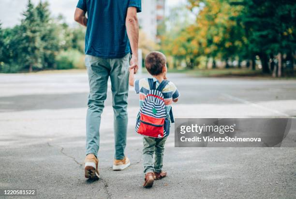 father and son going to kindergarten. - rear view stock pictures, royalty-free photos & images