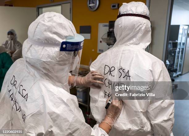 Health care worker writes the name of the doctor with a marker on the protective suit in the Covid-19 Infectious Diseases ward of the San Marco...