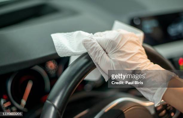 female hands with white  glove wiping car steering wheel with disinfectant wipe - clean car interior stock pictures, royalty-free photos & images
