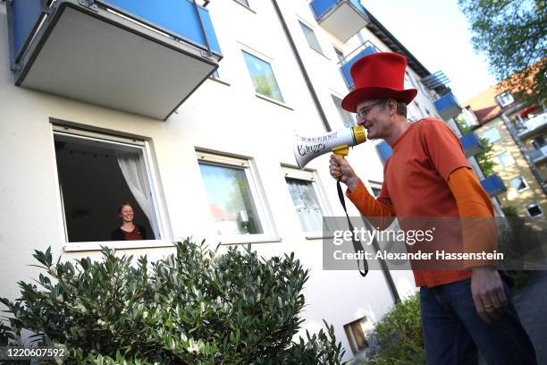 Performing artist Max Auerbach announces bingo numbers to participants playing from their balconies during the novel coronavirus crisis on April 23,...