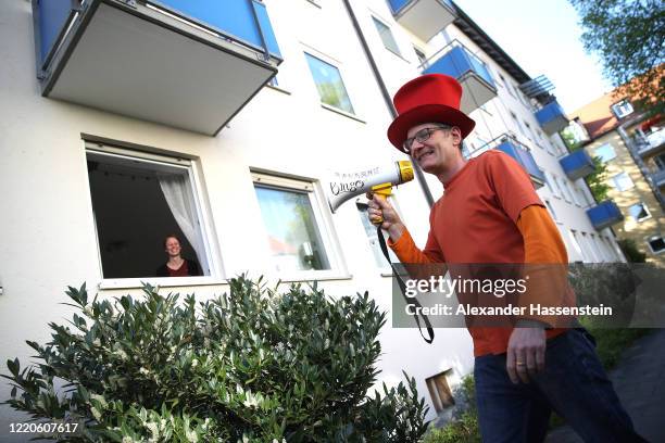 Performing artist Max Auerbach announces bingo numbers to participants playing from their balconies during the novel coronavirus crisis on April 23,...