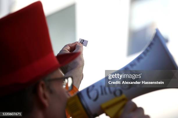 Performing artist Max Auerbach announces bingo numbers to participants playing from their balconies during the novel coronavirus crisis on April 23,...