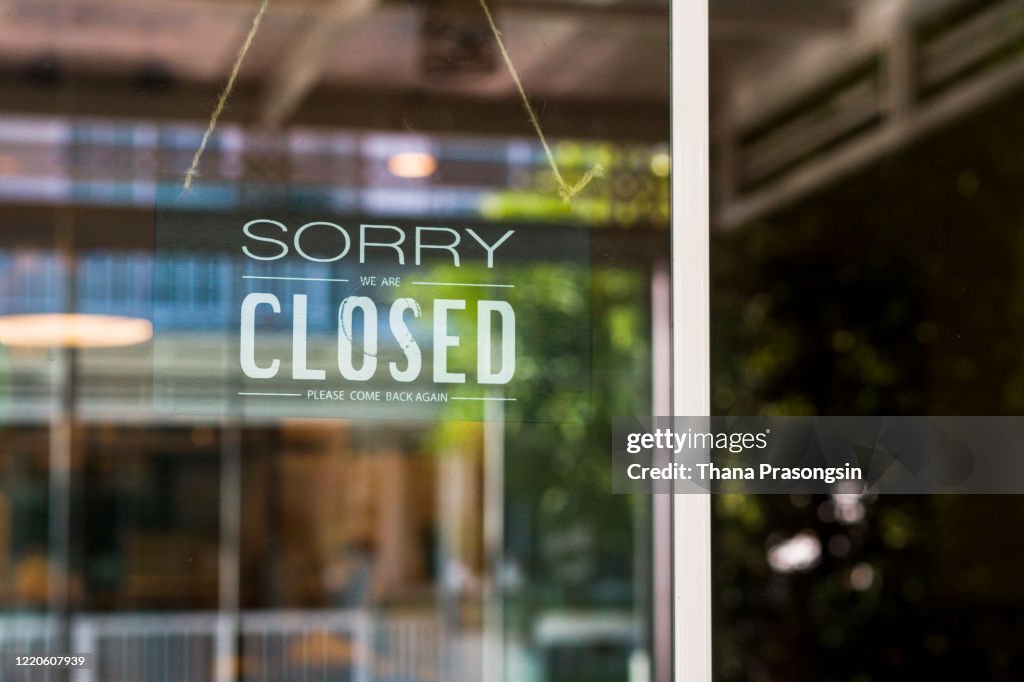 Store closed sign hanging on the window