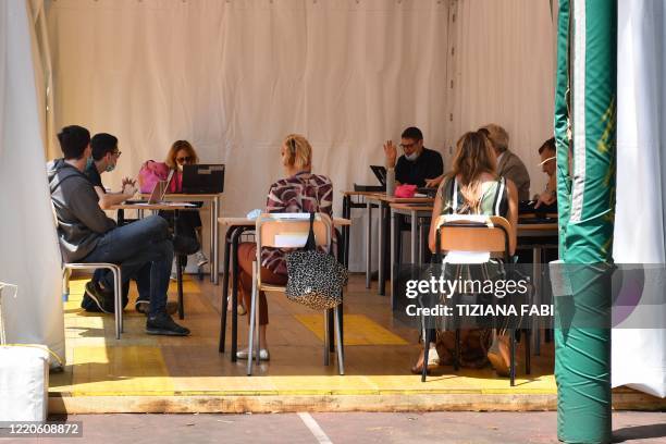 High school student pass the Baccalaureat examination on June 17, 2020 under a tent set up in the yard at the J. F. Kennedy High School in Rome, as...