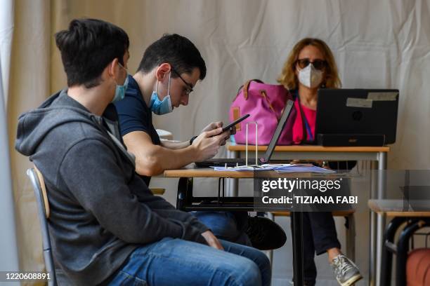 High school students pass the Baccalaureat examination on June 17, 2020 under a tent set up in the yard at the J. F. Kennedy High School in Rome, as...