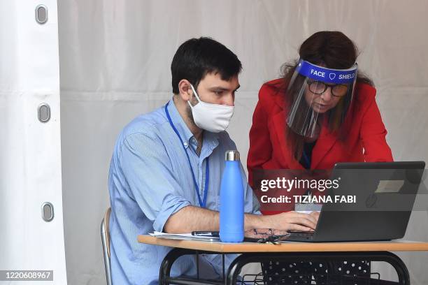 Examiners survey the Baccalaureat examination on June 17, 2020 under a tent set up in the yard at the J. F. Kennedy High School in Rome, as the...