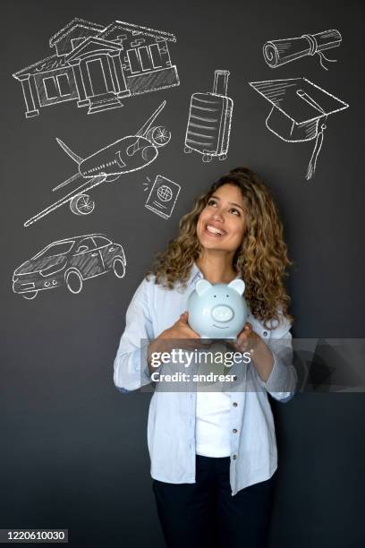 young woman saving in a piggybank to achieve her goals - daydreaming travel stock pictures, royalty-free photos & images