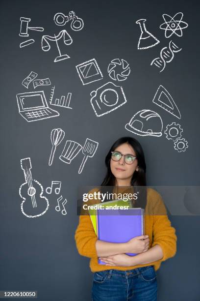 happy student thinking about what to study as her major - alternative imagens e fotografias de stock