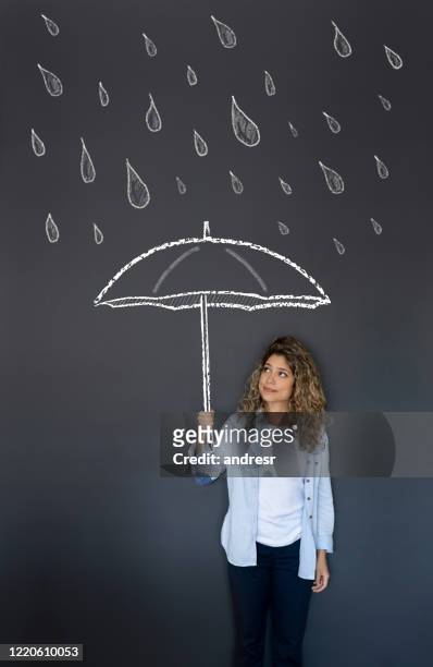 woman holding an umbrella under the rain - holding umbrella stock pictures, royalty-free photos & images