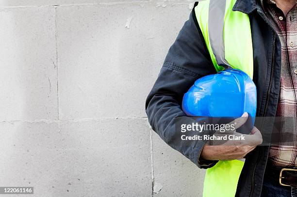 builder holding a hard hat - construction worker safety equipment stock pictures, royalty-free photos & images
