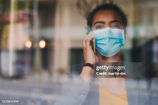 porträt einer geschäftsfrau mit schützender gesichtsmaske, covid-19-pandemie - op-mundschutz stock-fotos und bilder