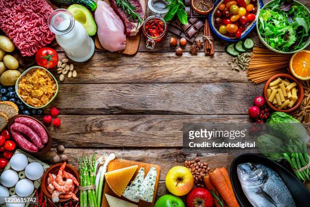 food backgrounds: large variety of food making a frame on rustic wooden table. copy space - chicken ingredient stock pictures, royalty-free photos & images