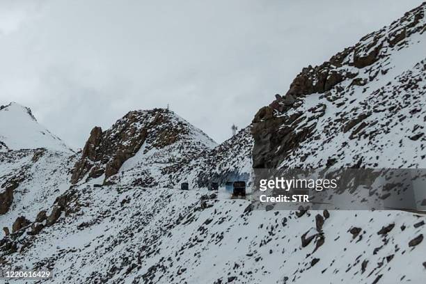 Indian Army vehicles drive on a road near Chang La high mountain pass in northern India's Ladakh region of Jammu and Kashmir state near the border...