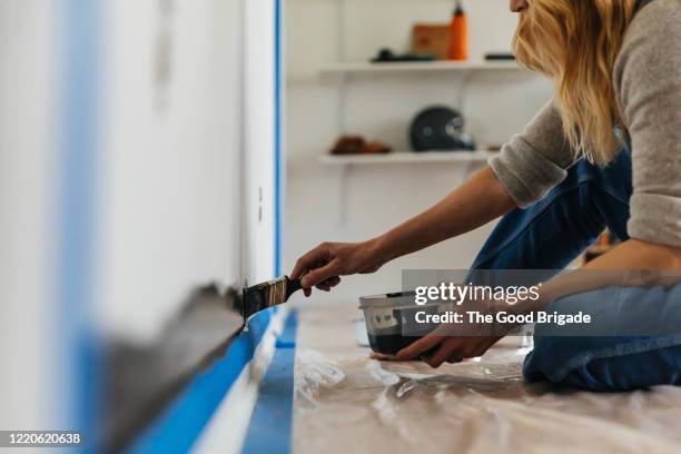 woman sitting painting wall at home - home renovation stock pictures, royalty-free photos & images