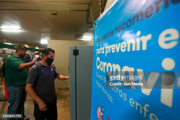 Passengers wear protective masks while buying a ticket for a subway train on April 20, 2020 in Guadalajara, Mexico. Mexico started what the...