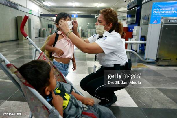 Officer helps children tu put on a protective masks at subway station on April 23, 2020 in Guadalajara, Mexico started what the authorities call...