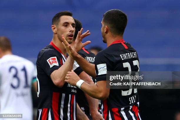 Frankfurt's Portuguese forward Andre Silva celebrates scoring the opening goal with his teammates during the German first division Bundesliga...