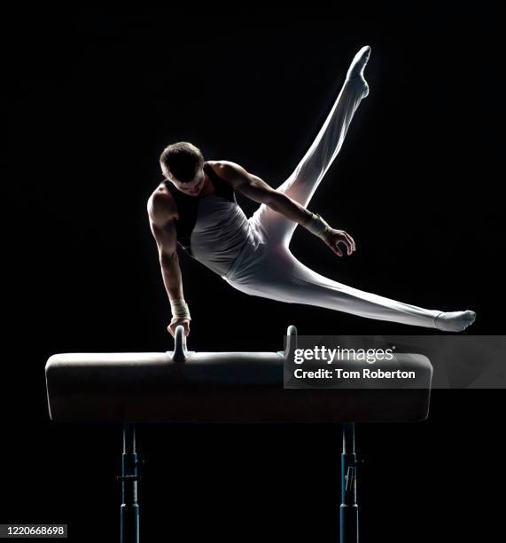 young male gymnast performing swing scissors on pommel horse - artistic gymnastics stock pictures, royalty-free photos & images