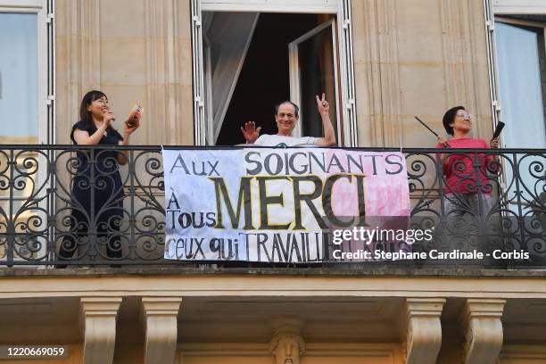 People applaud on their balcony in support of caregivers and medical workers as the lockdown continues due to the coronavirus outbreak on April 23,...