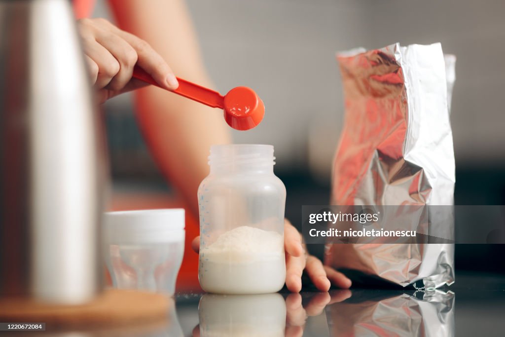 Mom Preparing Formula in Baby Bottle at Home