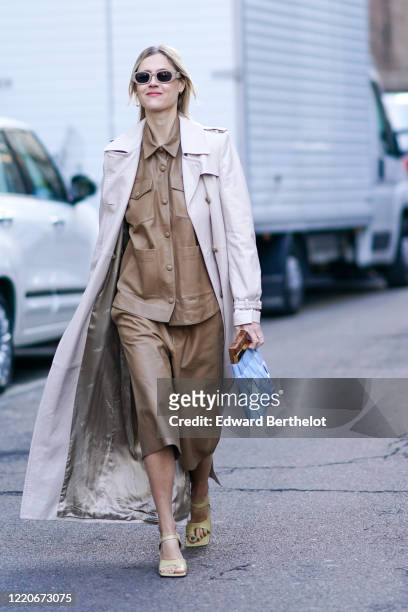 Linda Tol wears sunglasses, a white long coat, a brown leather jacket, a skirt, yellow shoes, outside Max Mara, during Milan Fashion Week Fall/Winter...