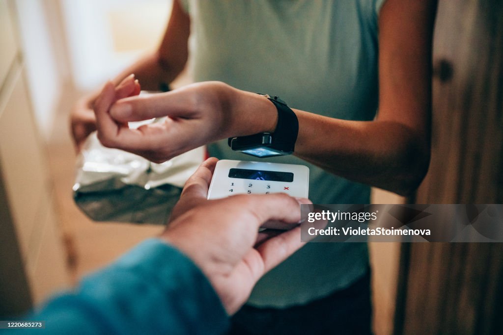 Woman paying contactless with smartwatch