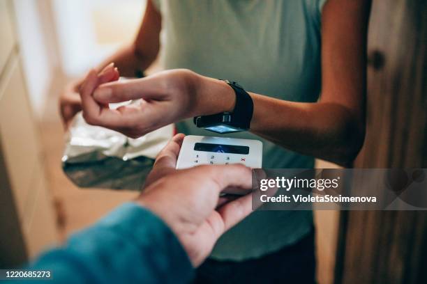 woman paying contactless with smartwatch - smartwatch pay stock pictures, royalty-free photos & images