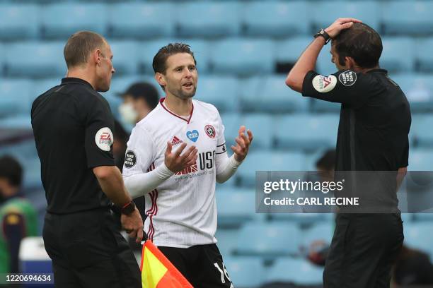 Sheffield United's English-born Northern Irish midfielder Oliver Norwood speaks with English referee Michael Oliver after the English Premier League...