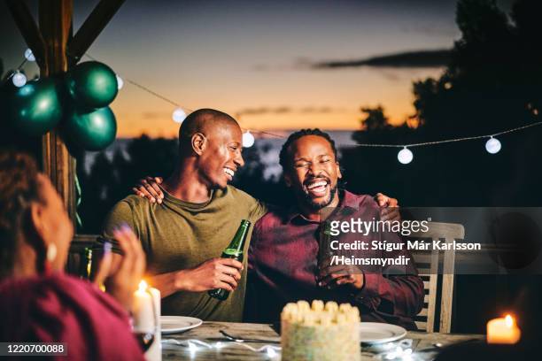 cheerful friends enjoying beer in birthday party - balcony decoration stock pictures, royalty-free photos & images