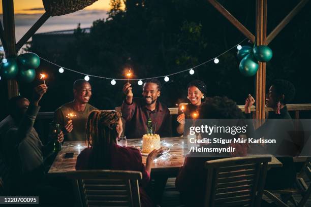 cheerful friends with glowing sparklers in party - balcony party stock pictures, royalty-free photos & images