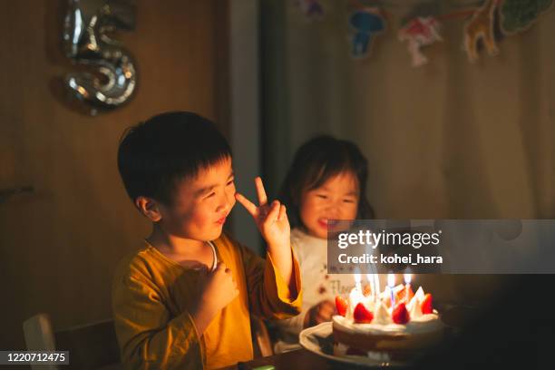 誕生日ケーキの前に座っている兄弟姉妹 - birthday cake ストックフォトと画像