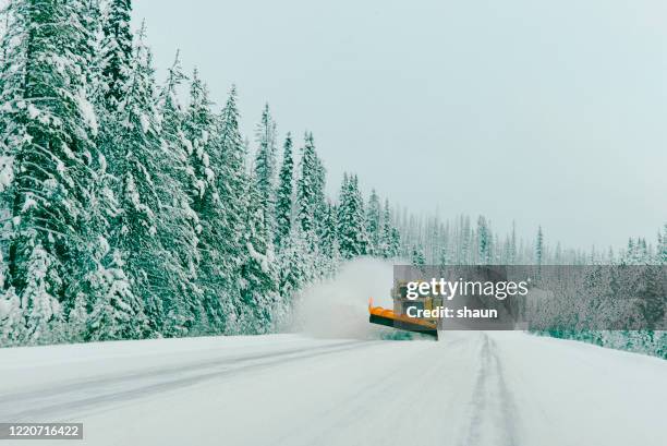 a snow plough clearing a road in the canadian rockies - snow plow stock pictures, royalty-free photos & images