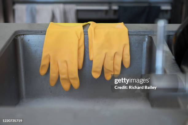 yellow washing up gloves hanging over kitchen sink - washing up glove bildbanksfoton och bilder