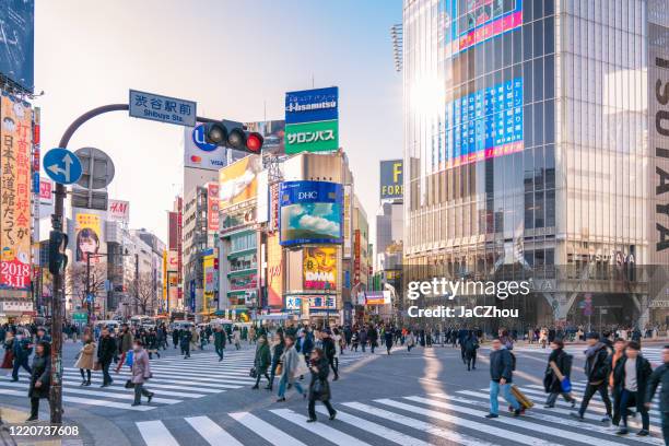 pedestrians crossing the street at shibuya crossing with motion blur - shibuya ward stock pictures, royalty-free photos & images